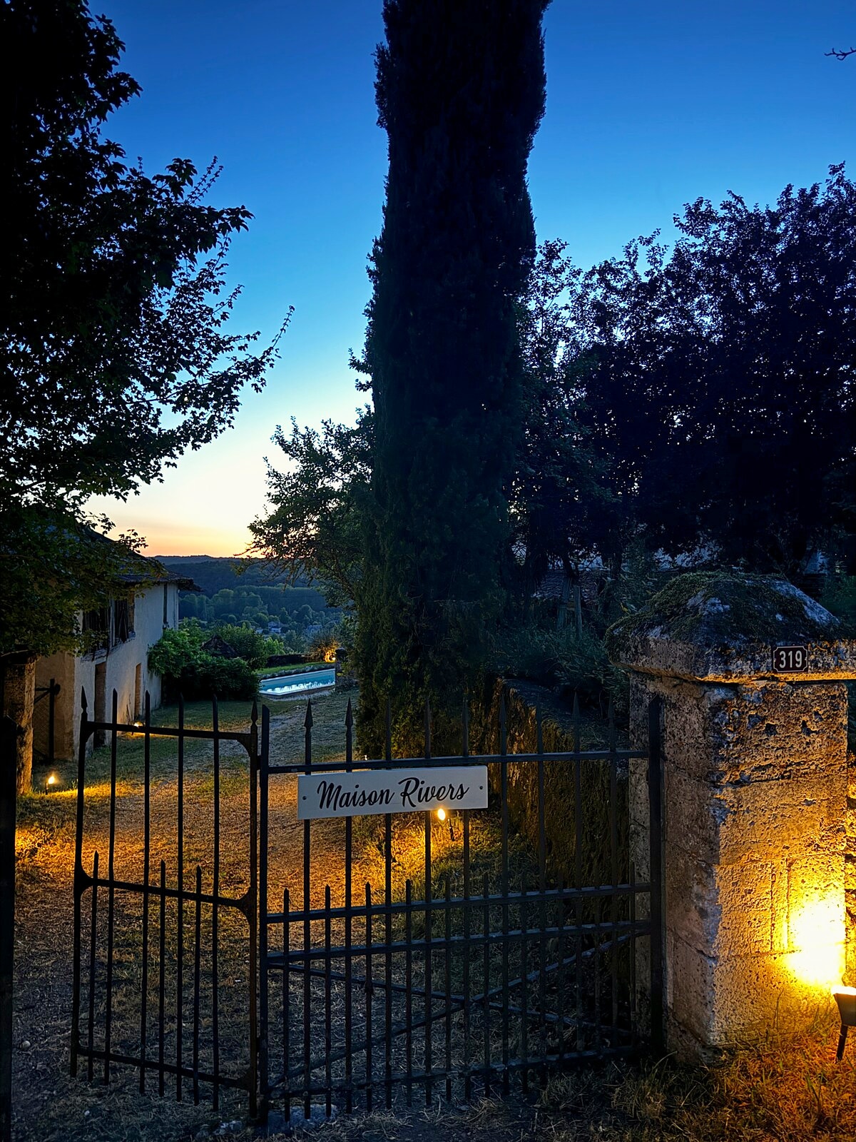 The old entrance gates to Maison Rivers lit in the evening