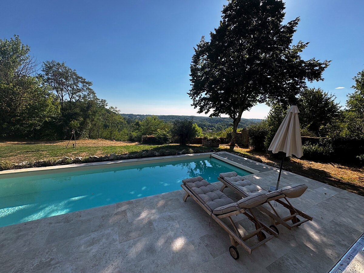 The lap pool framed by lawn, trees and open countryside