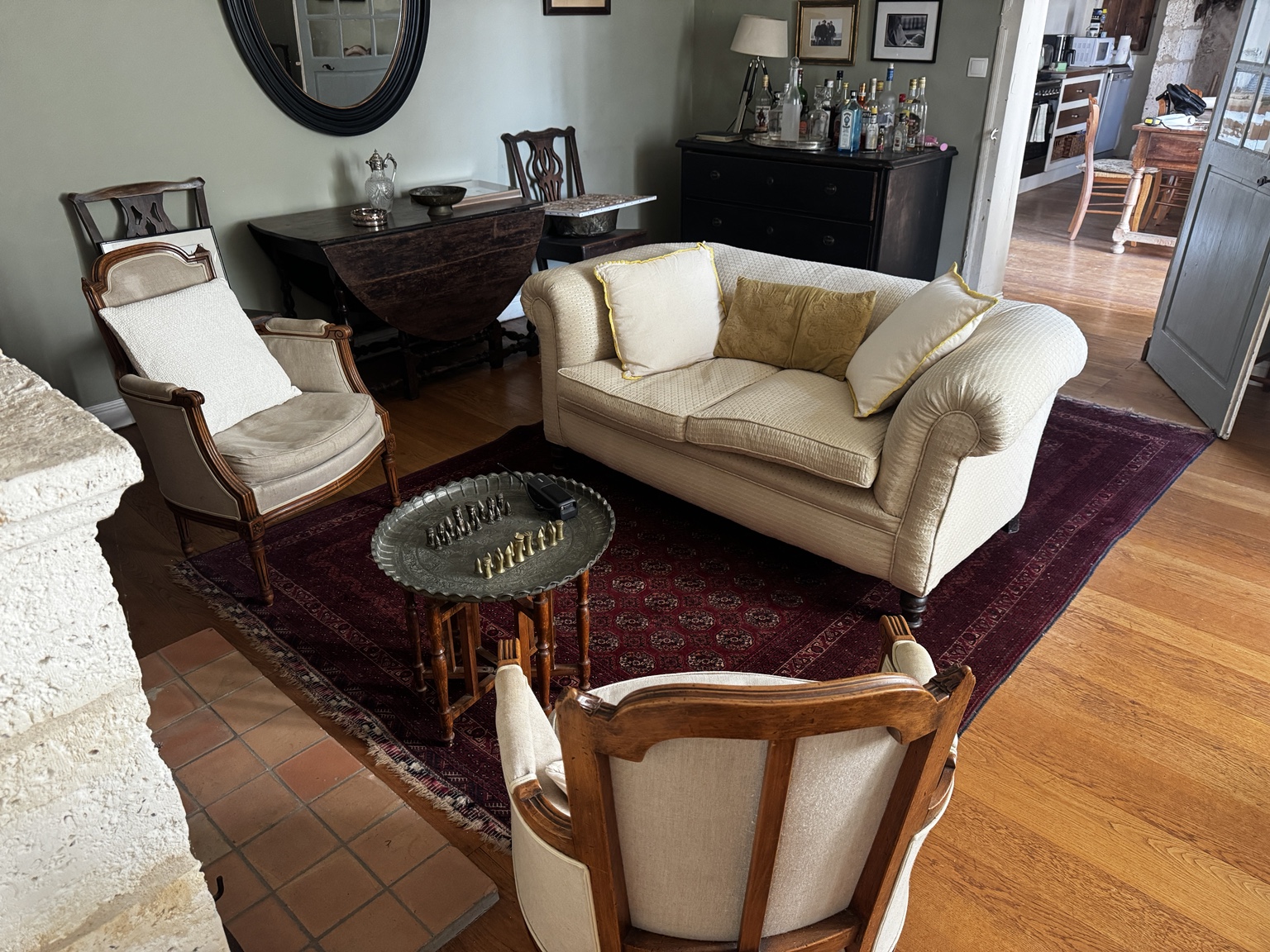 The characterful salon at Maison Rivers, with stone walls, antique furniture and a fireplace