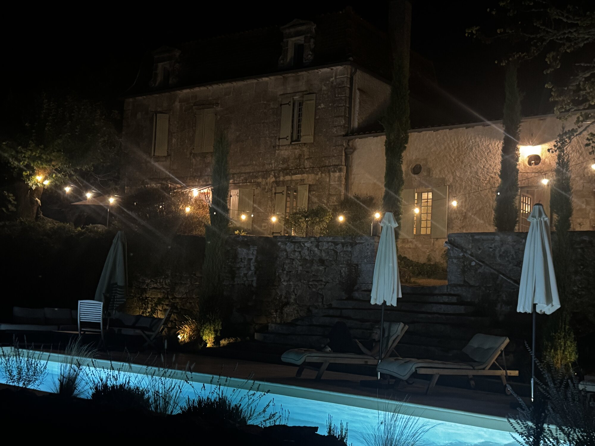 Maison Rivers and its swimming pool illuminated after dark